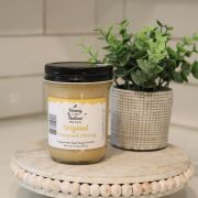 pure creamed honey on small platform on kitchen counter with green plant