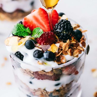 honey, yogurt and berry parfait with granola in glass dish