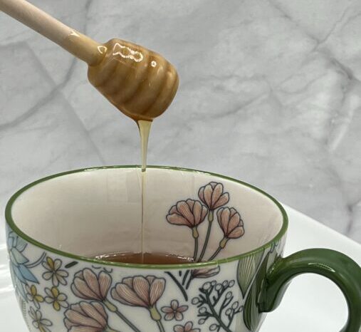 Honey poured into cup of tea